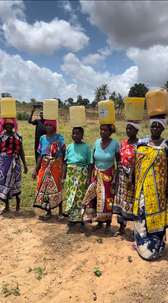 Residents of Nguluweni carrying buckets of water on their heads from watering hole
